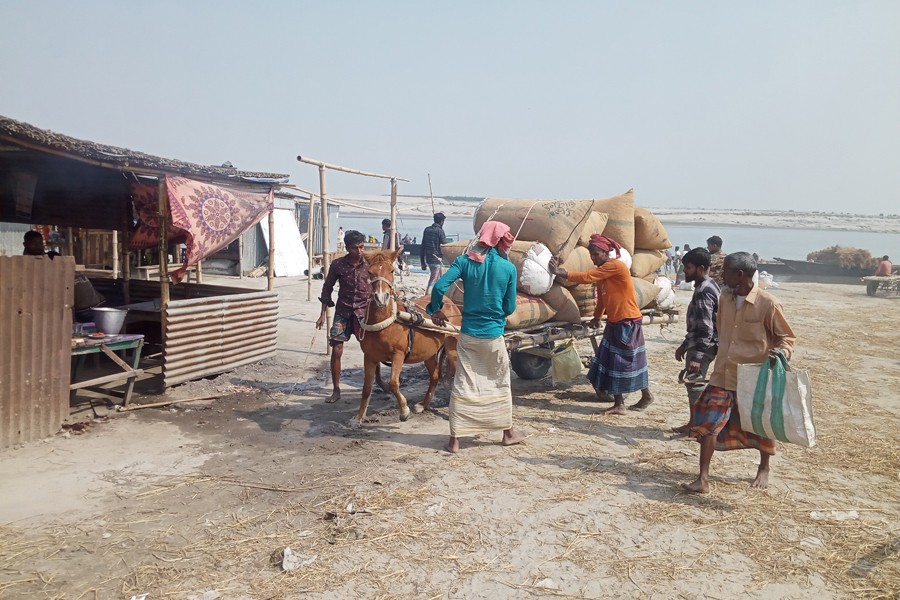 A horse cart running slowly with goods at Khatiamari char in Phulchhari upazila of Gaibandha district