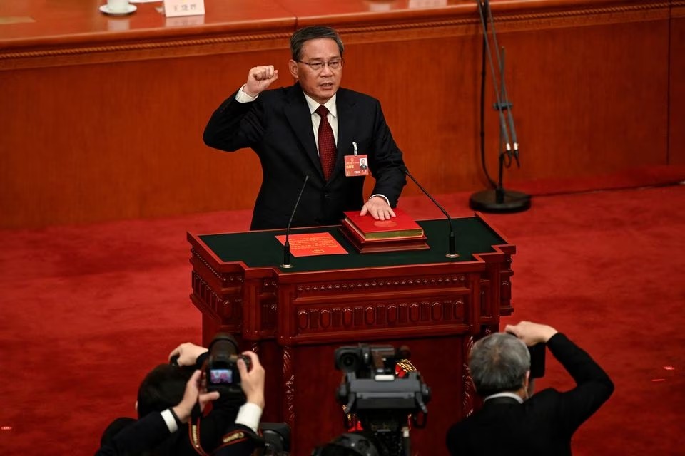 China's newly-elected Premier Li Qiang takes an oath after being elected during the fourth plenary session of the National People's Congress (NPC) at the Great Hall of the People in Beijing, China on March 11, 2023 — Pool via REUTERS