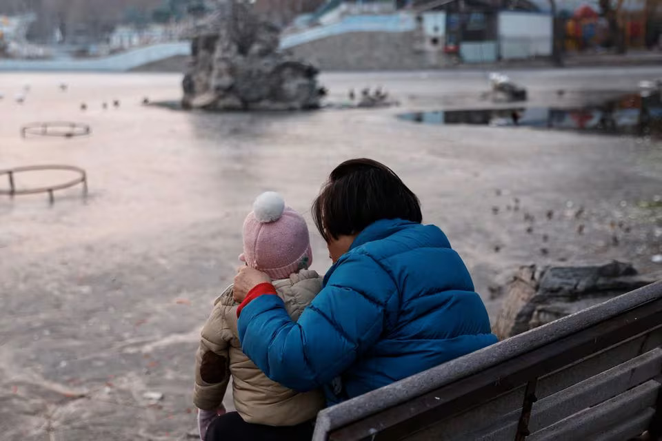 A woman and a child sit in a park in Beijing, China on January 12, 2024 — Reuters/File