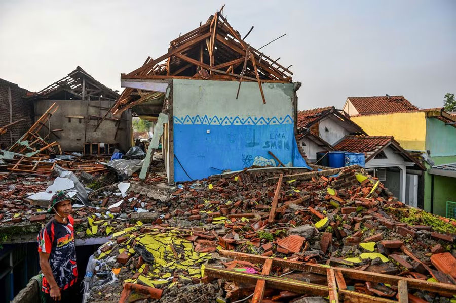 A man stands near damaged houses following a tornado at Sukadana village in Sumedang, West Java province, Indonesia, February 22, 2024.