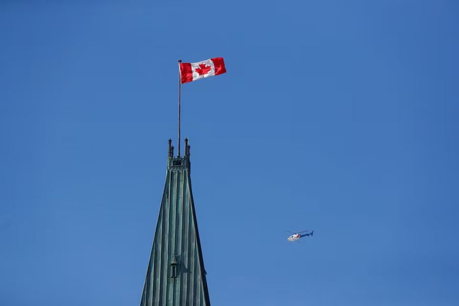 Royal Canadian Mounted Police (RCMP) helicopter flies past the Peace Tower on Parliament Hill, during the visit of US President Joe Biden, in Ottawa, Ontario, Canada, March 24, 2023.