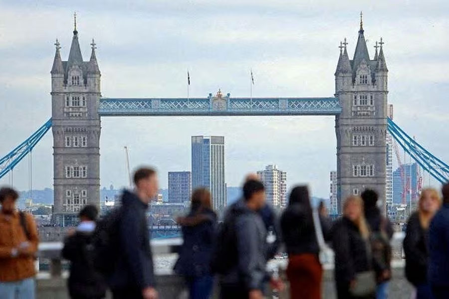 People walk over London Bridge with at a view of Tower Bridge in the City of London financial district, in London, Britain, October 25, 2023.