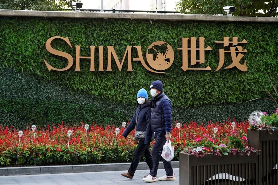 People walk past the logo of property developer Shimao Group near Shimao Tower in Shanghai, China January 13, 2022.