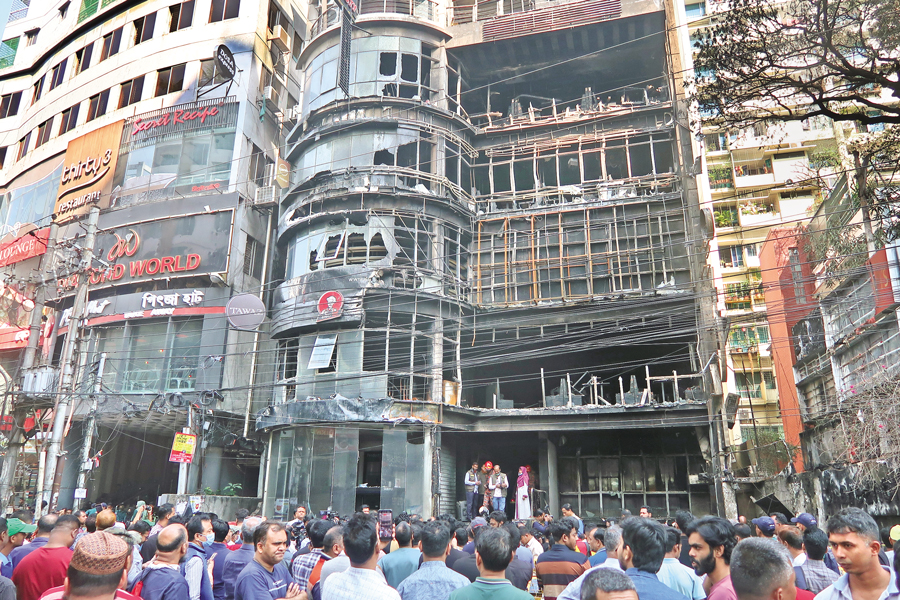 Crowds gather near the fire-damaged Green Cozy Cottage building on Bailey Road in Dhaka. The fire engulfed the building on Thursday night, killing 46 people. — FE Photo by Shafiqul Alam