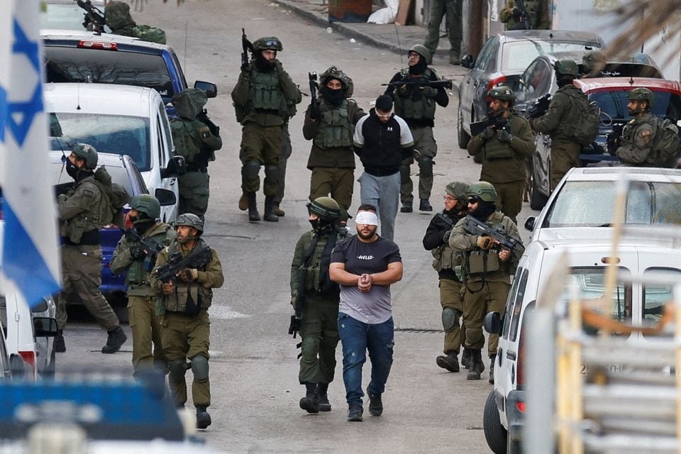 Israeli soldiers detain Palestinians during a raid, in Ramallah, in the Israeli-occupied West Bank on March 4, 2024 — Reuters photo