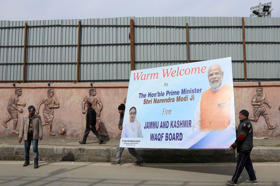 People carry a hoarding board outside the Bakshi stadium a day ahead of Indian Prime Minister Narendra Modi's visit, in Srinagar, March 6, 2024.