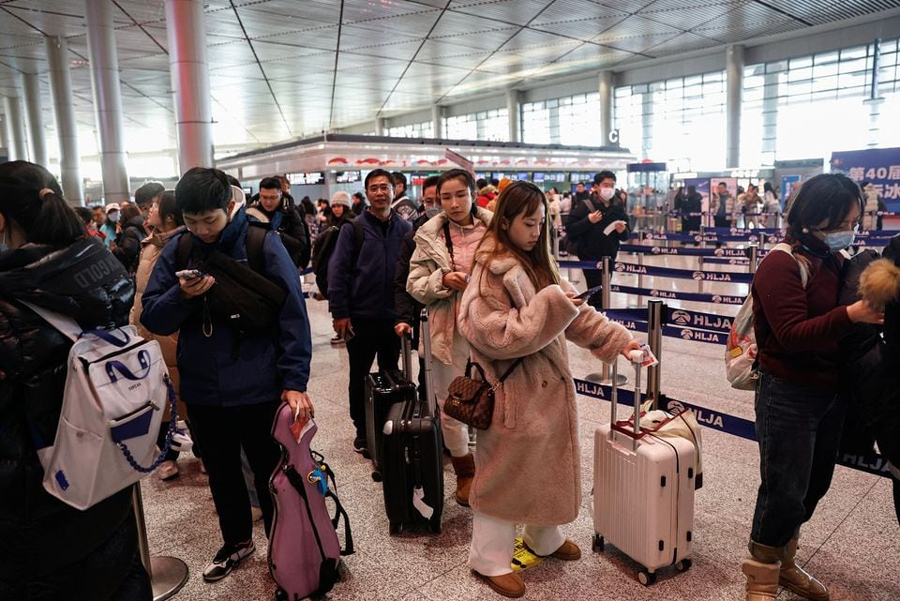 People wait in line to go through the security check at an airport in Harbin, Heilongjiang province, China January 8, 2024.