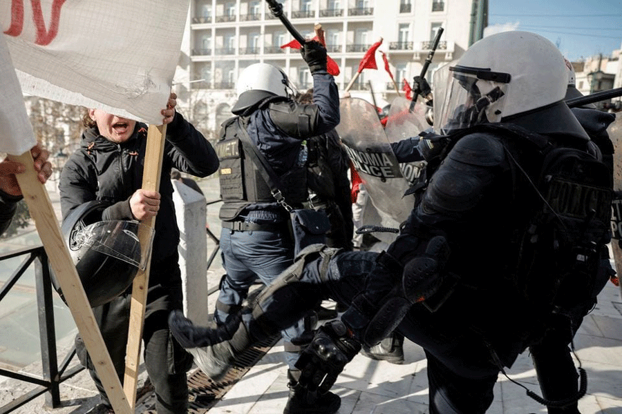 Police kicks a protester during a demonstration before the voting of a planned bill which opens the way for the operation of foreign private universities, in Athens, Greece, March 8, 2024.