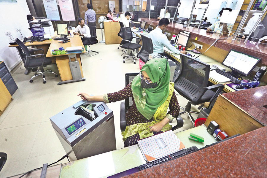 A bank teller counting notes at a bank branch in Dhaka