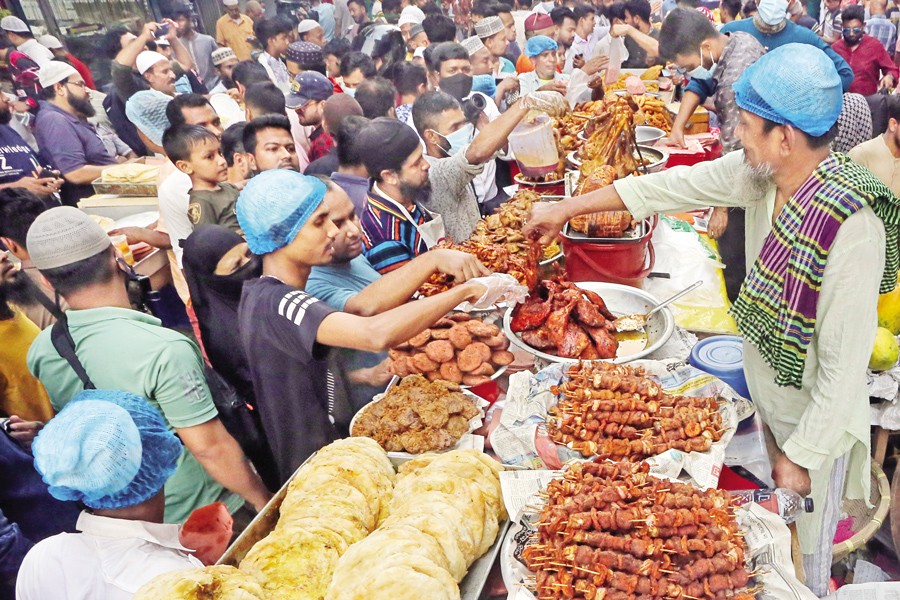 People from across the city throng the temporary stalls laden with iftar delicacies at the century-old Iftar market in Dhaka's Chawkbazar. But rising commodity prices cast a shadow, forcing many to rein in their spending on these tempting treats. —FE Photo by Asad-Uz-Zaman