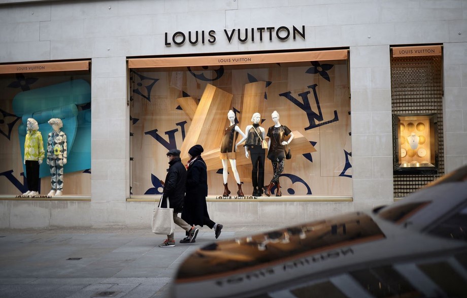 People walk outside a Louis Vuitton store on New Bond Street in London, Britain, March 11, 2023. REUTERS/Henry Nicholls