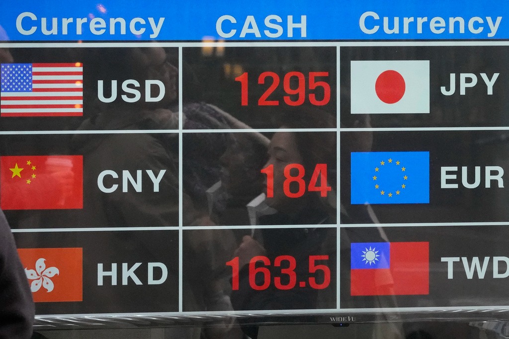 A woman is reflected on an electronic foreign currency exchange rates in downtown Seoul, South Korea, Wednesday, March 15, 2023.