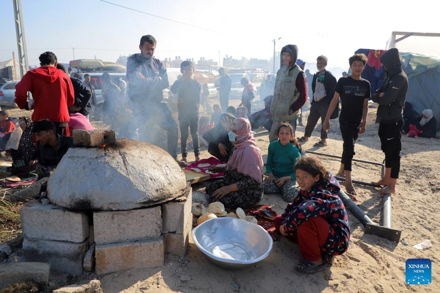 Displaced Palestinians prepare food at a temporary shelter in the southern Gaza Strip city of Rafah, on December 18, 2023—Xinhua Photo