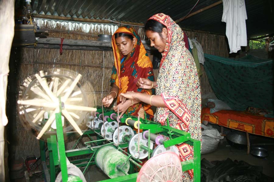 Two female workers spinning yarn at a handloom factory in Sarotia village in Belkuchi upazila of Sirajganj district — FE Photo