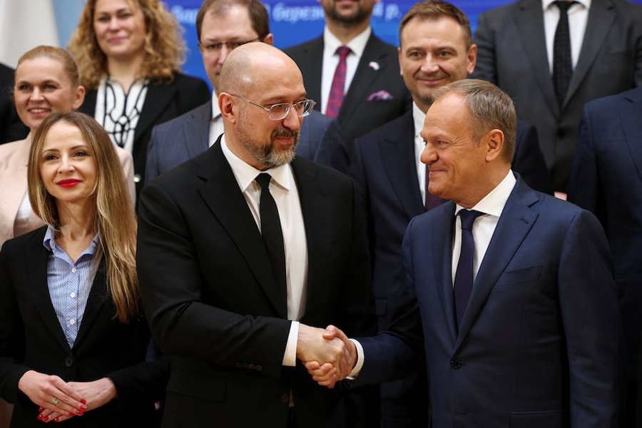 Polish Prime Minister Donald Tusk and Ukrainian Prime Minister Denys Shmyhal shake hands during a group photo, as they meet for bilateral talks in Warsaw, Poland, March 28, 2024.