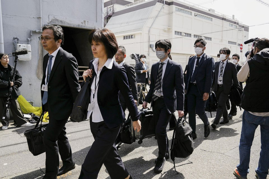 Japanese health ministry officials head to search a Kobayashi Pharmaceutical Co. factory in Osaka, Japan March 30, 2024, in this photo taken by Kyodo.