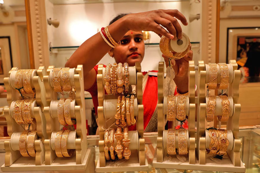 A saleswoman shows gold bangles to a customer at a jewellery showroom on the occasion of Akshaya Tritiya, a major gold buying festival, in Kolkata, India, May 3, 2022.