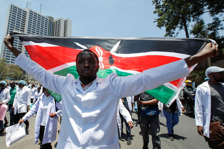 A medical practitioner carry a Kenyan flag as he participates in a demonstration against the government's failure to hire trainee doctors in Nairobi, Kenya, March 22 2024.