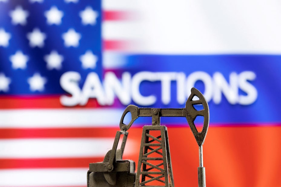 A model of a pump jack is seen in front of the displayed word “Sanctions”, US and Russia flag colours in this illustration taken March 8, 2022.