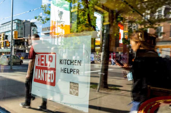 A help wanted sign hangs in a bar window along Queen Street West in Toronto Ontario, Canada June 10, 2022. REUTERS/Carlos Osorio/FILE PHOTO