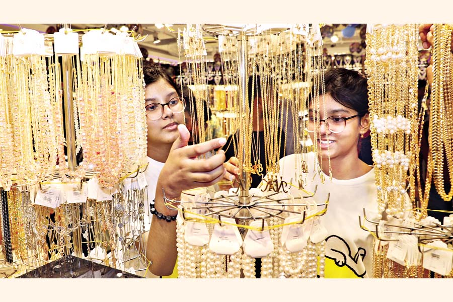 Two young girls look at ornaments in a city shopping mall on Sunday. Ornaments are a popular fashion accessory, often seen as the finishing touch to a festival makeover. Shoppers appear to be focusing on these smaller items after buying essential clothing and shoes for the upcoming Eid festival. — FE Photo