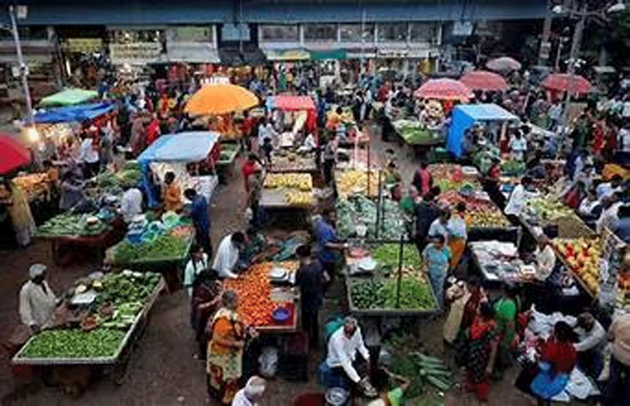 Customers buy fruits and vegetables at an open air evening market in Ahmedabad, India, August 21, 2023.