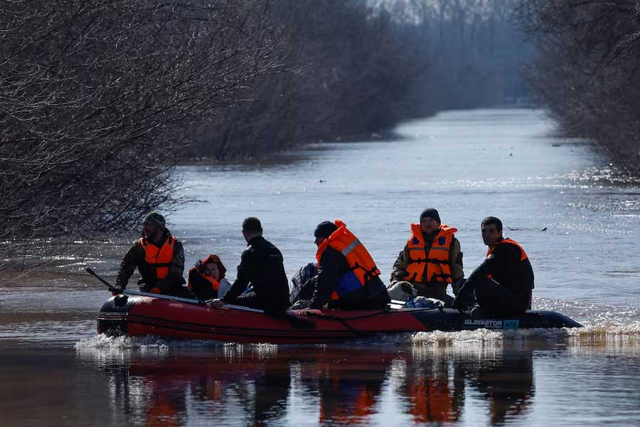 Rescuers from the Russian Emergencies Ministry evacuate people from a flooded residential area in Orenburg, Russia, April 11, 2024.