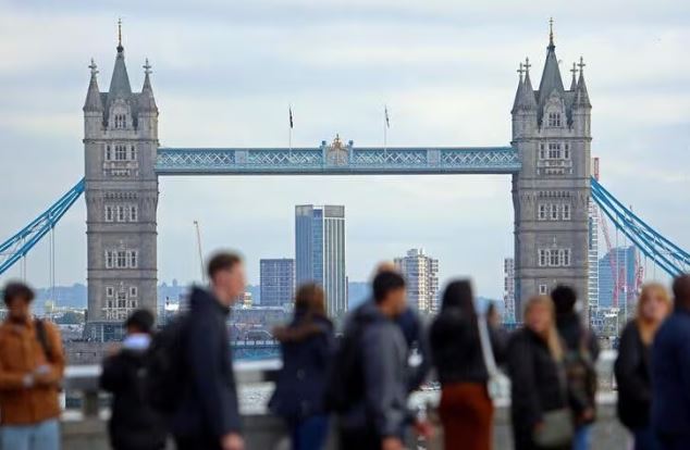People walk over London Bridge looking at a view of Tower Bridge in the City of London financial district in London, Britain, October 25, 2023. REUTERS/ Susannah Ireland