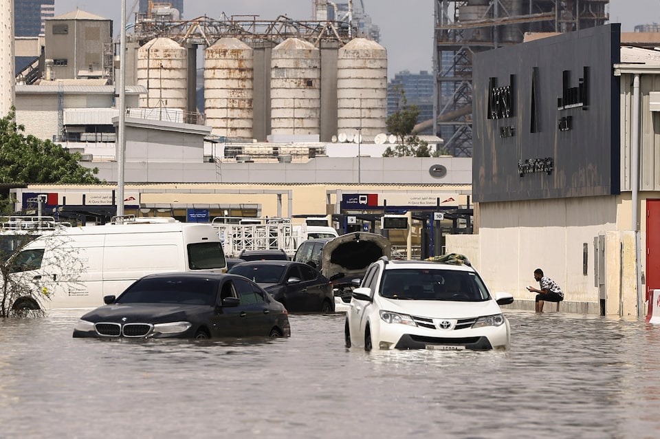 A person sits near vehicles stranded in flood water caused by heavy rains in Dubai, United Arab Emirates on April 17, 2024 — Reuters photo