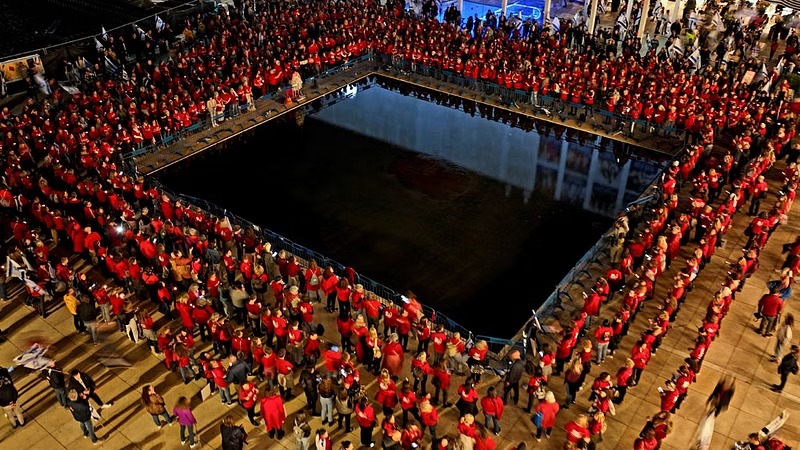 An aerial view shows women wearing red clothes during a demonstration as Israeli Prime Minister Benjamin Netanyahu's nationalist coalition government presses on with its contentious judicial overhaul, in Tel Aviv, Israel, March 18, 2023.