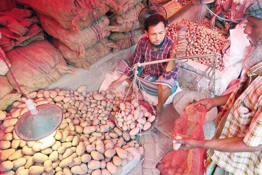 A potato trader weighs produce at Shyambazar wholesale market in Dhaka. Prices of kitchen staples, including potatoes, onions and garlic, rose further in the past week after Eid-ul-Fitr. — FE Photo