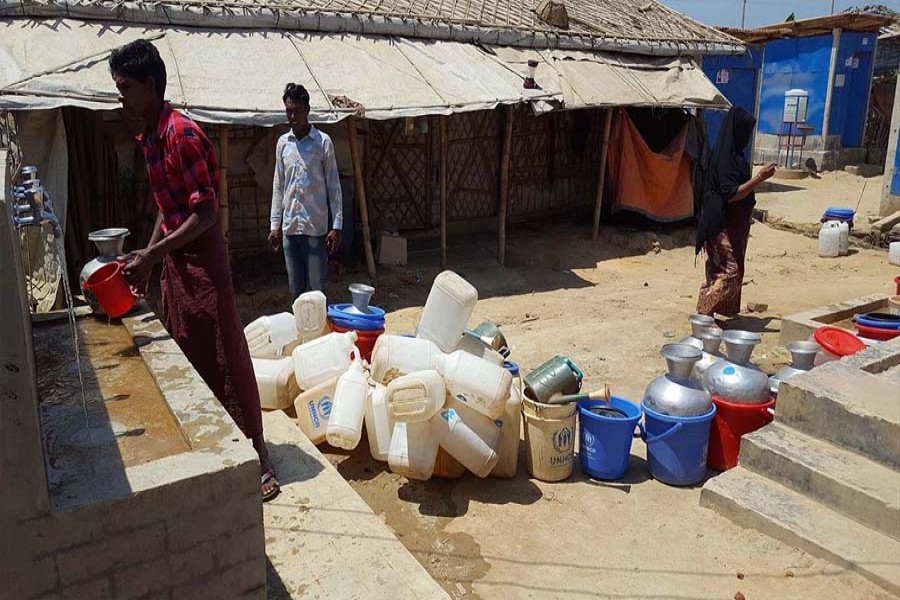 Rohingya people collecting drinking water from a shallow tube-well in a camp — FE Photo
