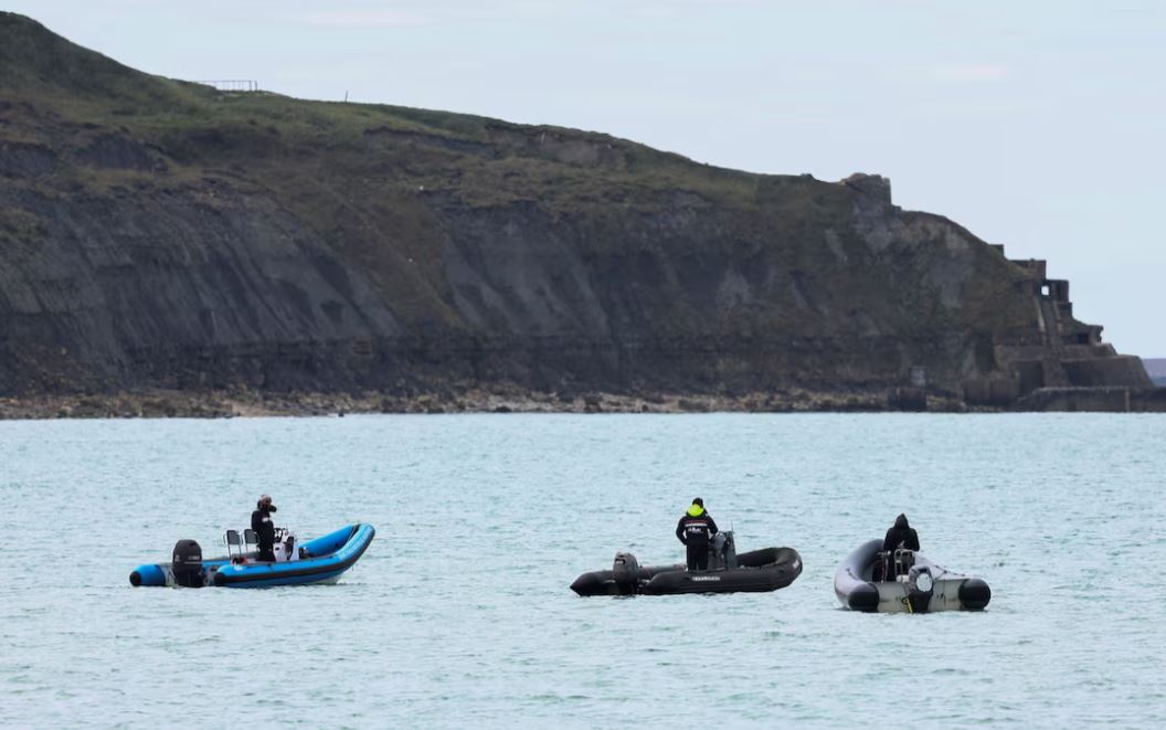 People stand on boats in Wimereux, near Calais, after migrants died in an attempt to cross the English Channel, in France, April 23, 2024. REUTERS/Yves Herman