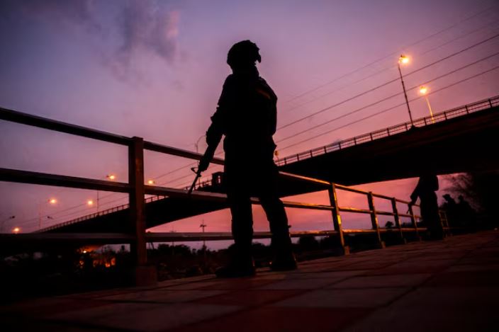 Military personnel stand guard as hundreds of refugees crossed over the river frontier between Myanmar and Thailand on Friday, following the fall of a strategic border town to rebels fighting Myanmar's military junta, in Mae Sot, Tak province, Thailand, April 13, 2024. REUTERS/Athit Perawongmetha/File Photo