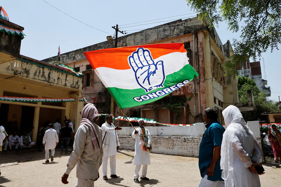 A supporter waves the flag of the Congress party before the arrival of Rahul Gandhi, a senior leader of India’s main opposition Congress party, in Raebareli, Uttar Pradesh, India, May 3, 2024.