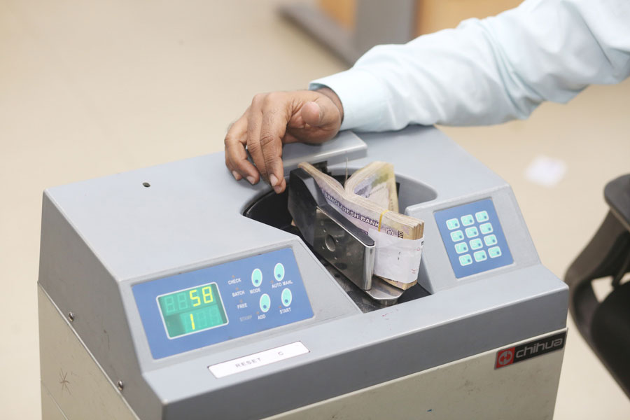 A teller is counting notes at a bank branch in Dhaka. Over the years, governance in the banking sector has become a matter of concern