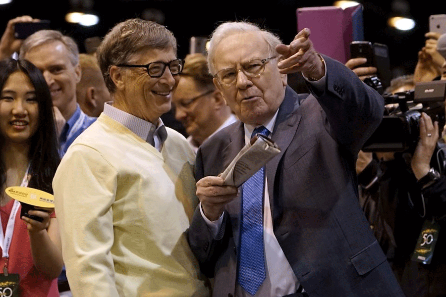 Berkshire Hathaway CEO Warren Buffett (R) shows his friend Microsoft co-founder Bill Gates the finer points of newspaper tossing, prior to the Berkshire annual meeting in Omaha, Nebraska May 2, 2015.
