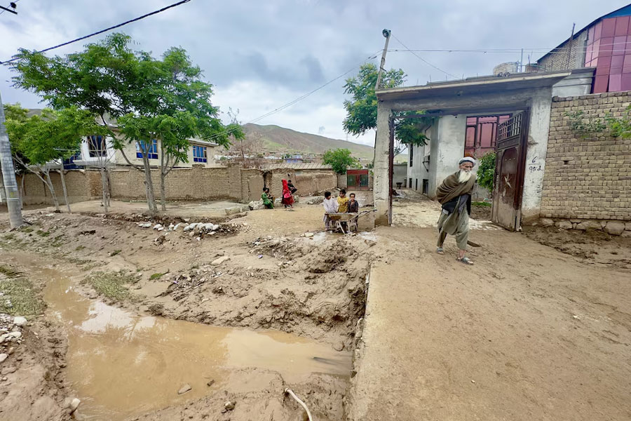 A man walks on a muddy path, in the aftermath of floods following heavy rain, in Kar Kar village, Baghlan province, Afghanistan May 11, 2024.
