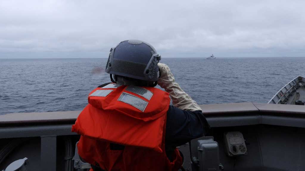 A Taiwanese sailor aboard a Taiwan Navy vessel looks towards a Chinese warship while navigating on waters off Taiwan's western coast, in this handout image released May 23, 2024. Taiwan Defence Ministry/Handout via REUTERS