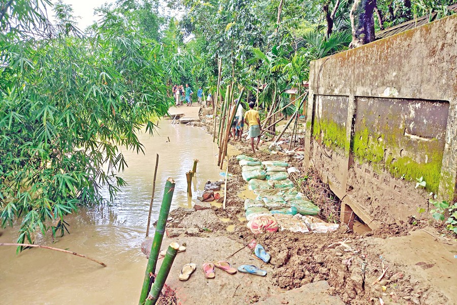 Workers carrying out emergency repair of the Surma dyke in Kanaighat upazila, Sylhet, on Saturday. — FE photo