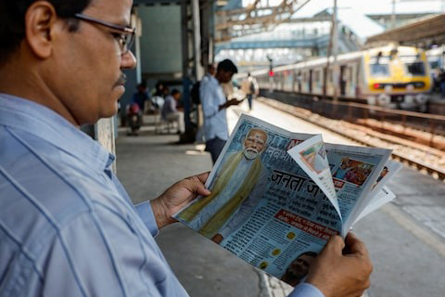 A man reads a newspaper on a railway station platform following the results of India's general election, in Mumbai, India, June 5, 2024.