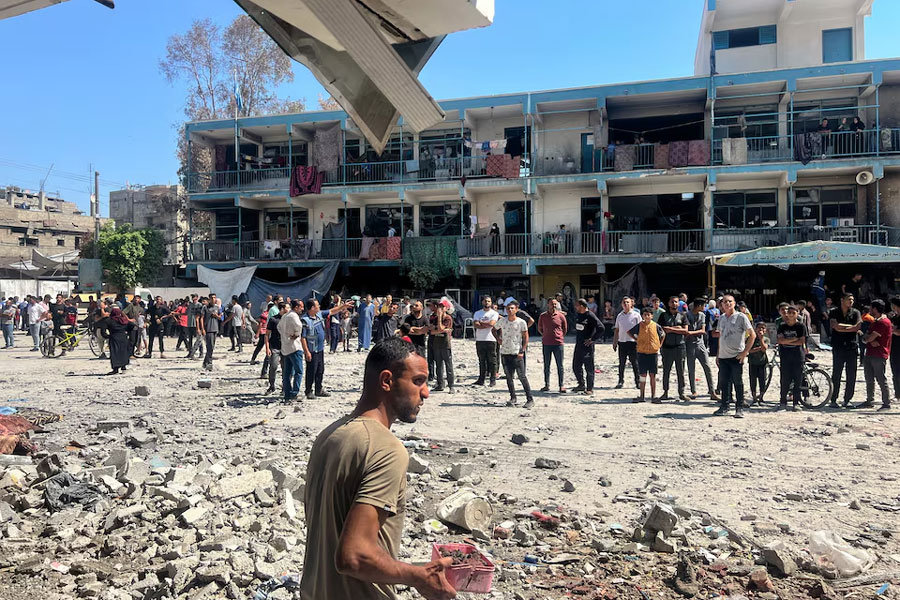 Palestinians inspect the site of an Israeli strike on a UNRWA school sheltering displaced people, amid the Israel-Hamas conflict, in Nuseirat refugee camp in the central Gaza Strip, June 6, 2024.