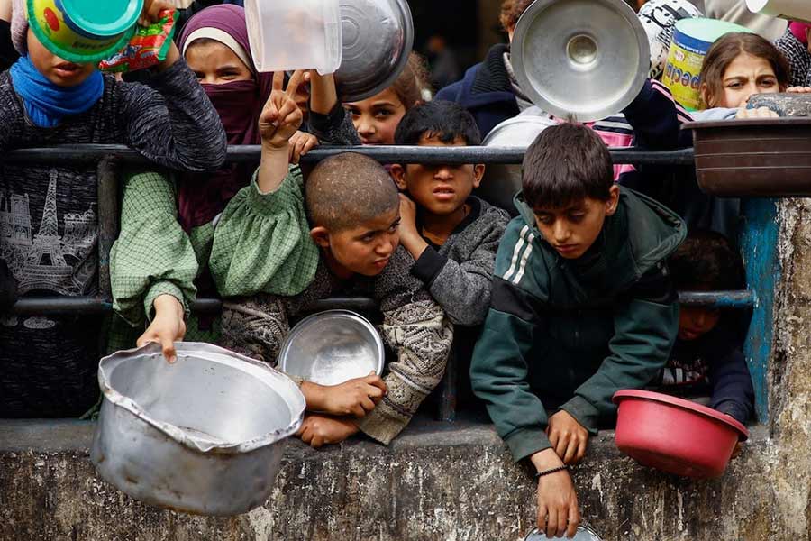 Palestinian children waiting to receive food cooked by a charity kitchen amid shortages of food supplies in Rafah, in the southern Gaza Strip, on February 13 this year –Reuters photo