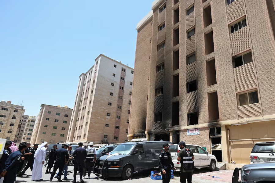 Kuwaiti police officers are seen in front of a burnt building following a deadly fire, in Mangaf, southern Kuwait on Wednesday -Reuters photo