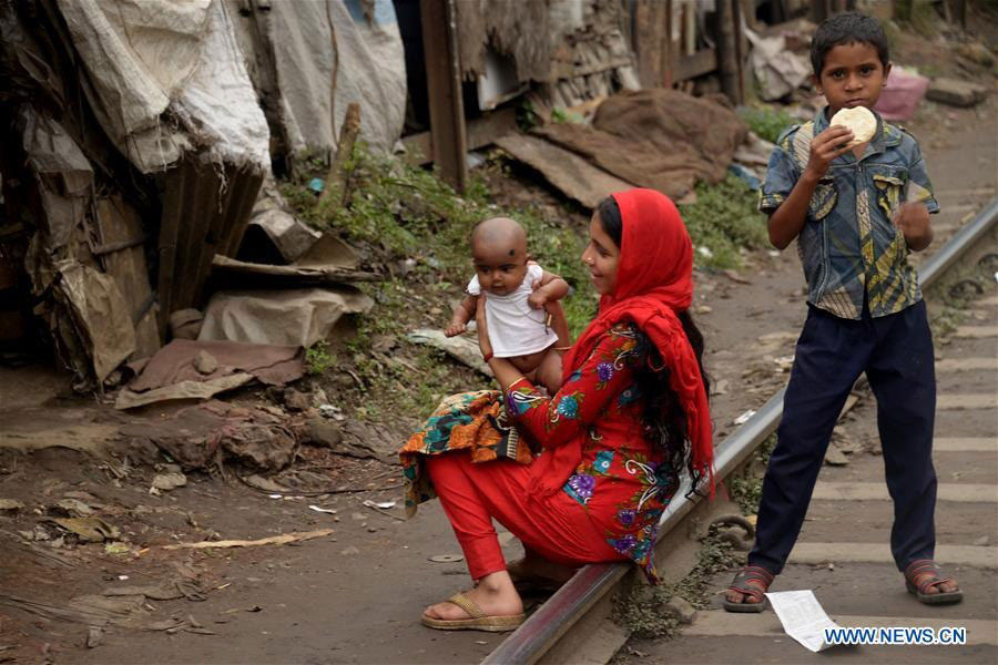 A woman plays with her child near her slum house in Dhaka. There are many slums and squatter settlements in Dhaka that lack of basic services reflecting acute poverty in the country