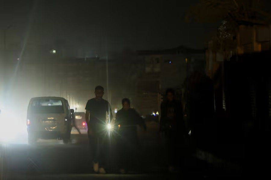 An Egyptian family uses a lantern on a street as power cuts to reduce energy consumption are executed by the Egyptian government during the current brutal heat wave, in Cairo, Egypt August 3, 2023.