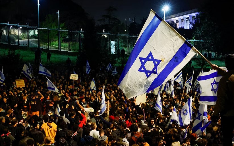 People attend a demonstration after Israeli Prime Minister Benjamin Netanyahu dismissed the defense minister and his nationalist coalition government presses on with its judicial overhaul, in Jerusalem, March 27, 2023. REUTERS
