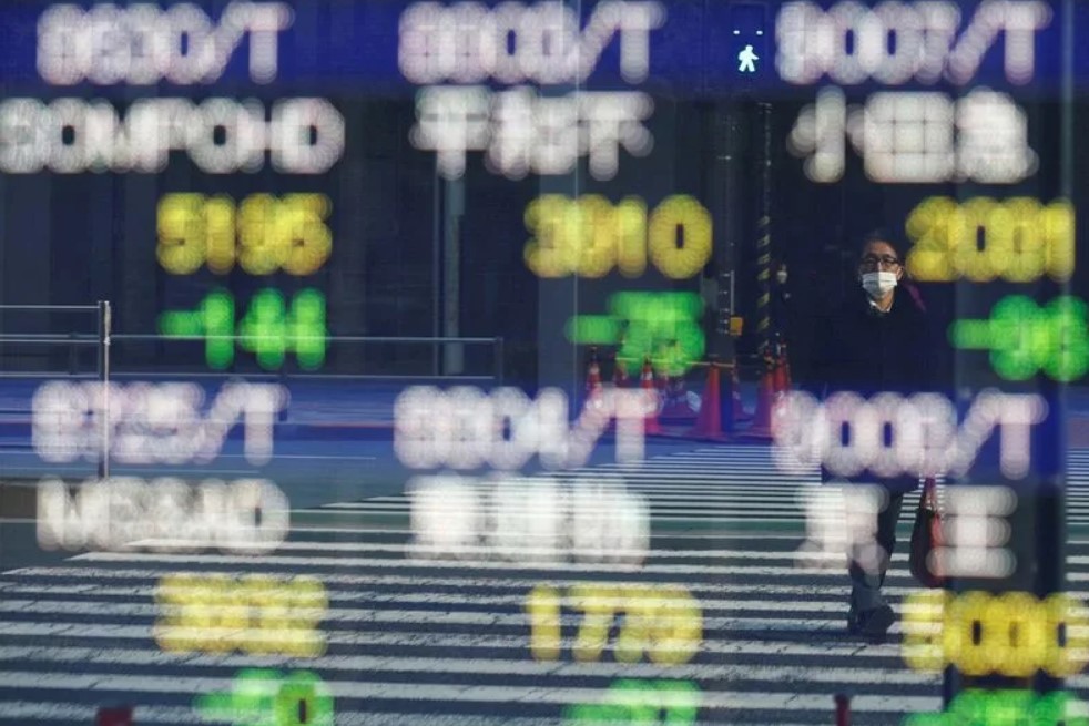 A man is reflected on an electronic board displaying various companies' stock prices outside a brokerage in Tokyo, Japan, February 22, 2022. REUTERS/Kim Kyung-Hoon/File Photo