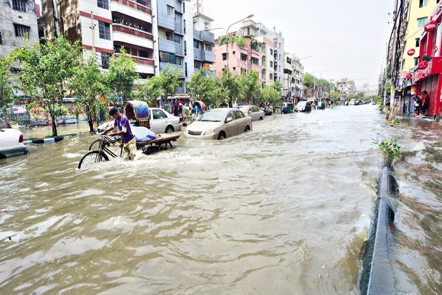Vehicles somehow plying the waterlogged Kalshi Road in the capital's Mirpur-Pallabi area that went under water following only 20 minutes of rain on Wednesday morning. The rainwater entered roadside houses and shops, damaging valuables and causing immense sufferings to the traders and dwellers