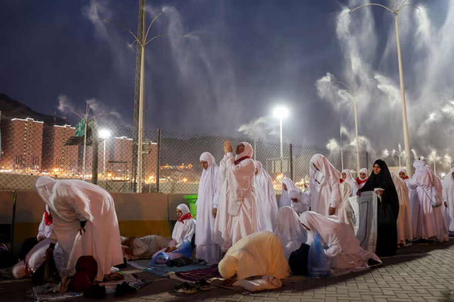 Muslim pilgrims pray as sprinklers spray water to cool them down amid extremely hot weather, during the annual hajj pilgrimage, in Mina, Saudi Arabia, June 16, 2024.